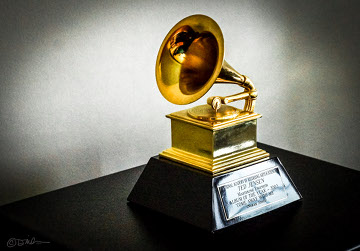 Gramophone award standing on a black table with a gray background